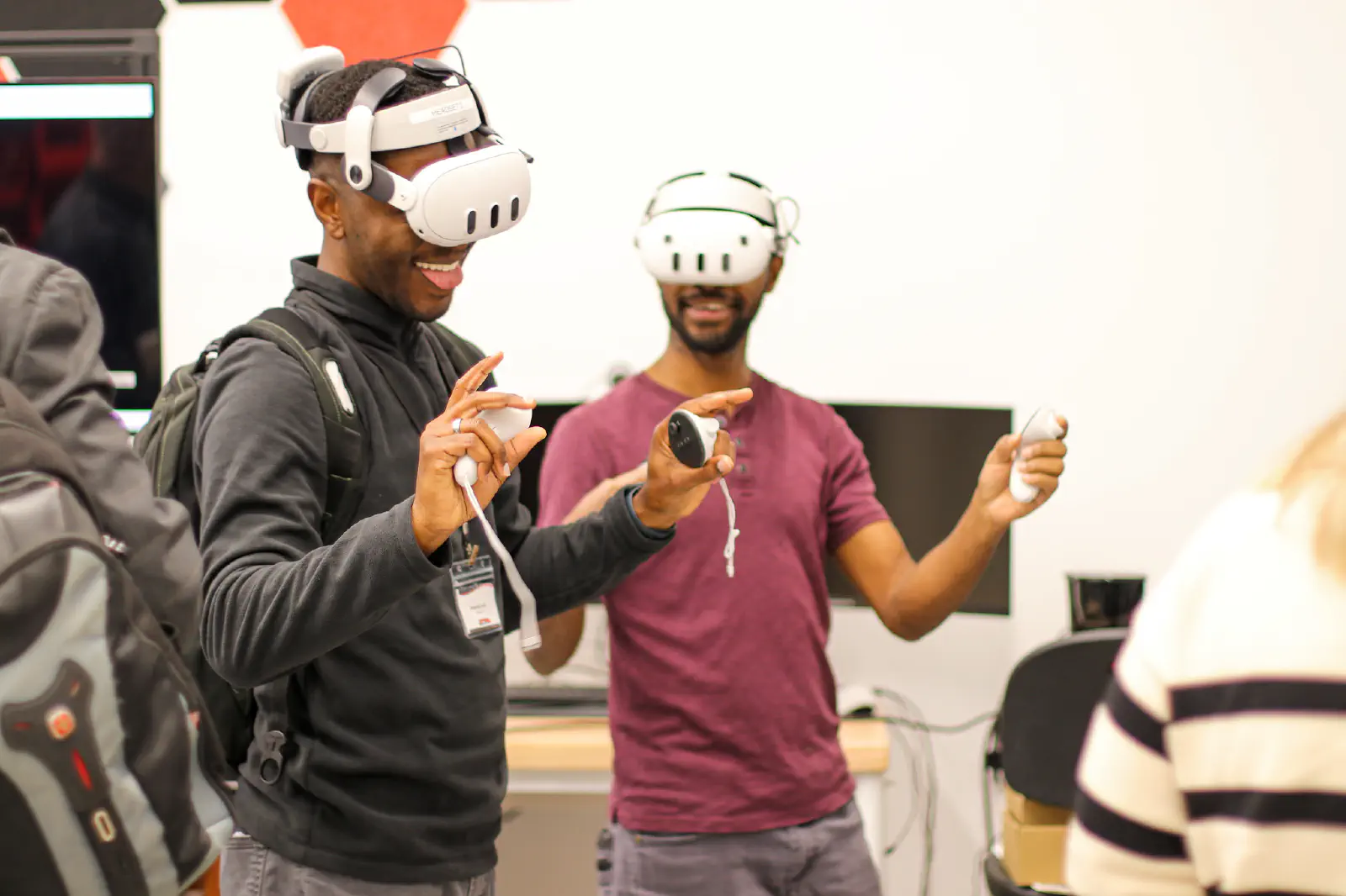 Two students wearing VR headsets and smiling.